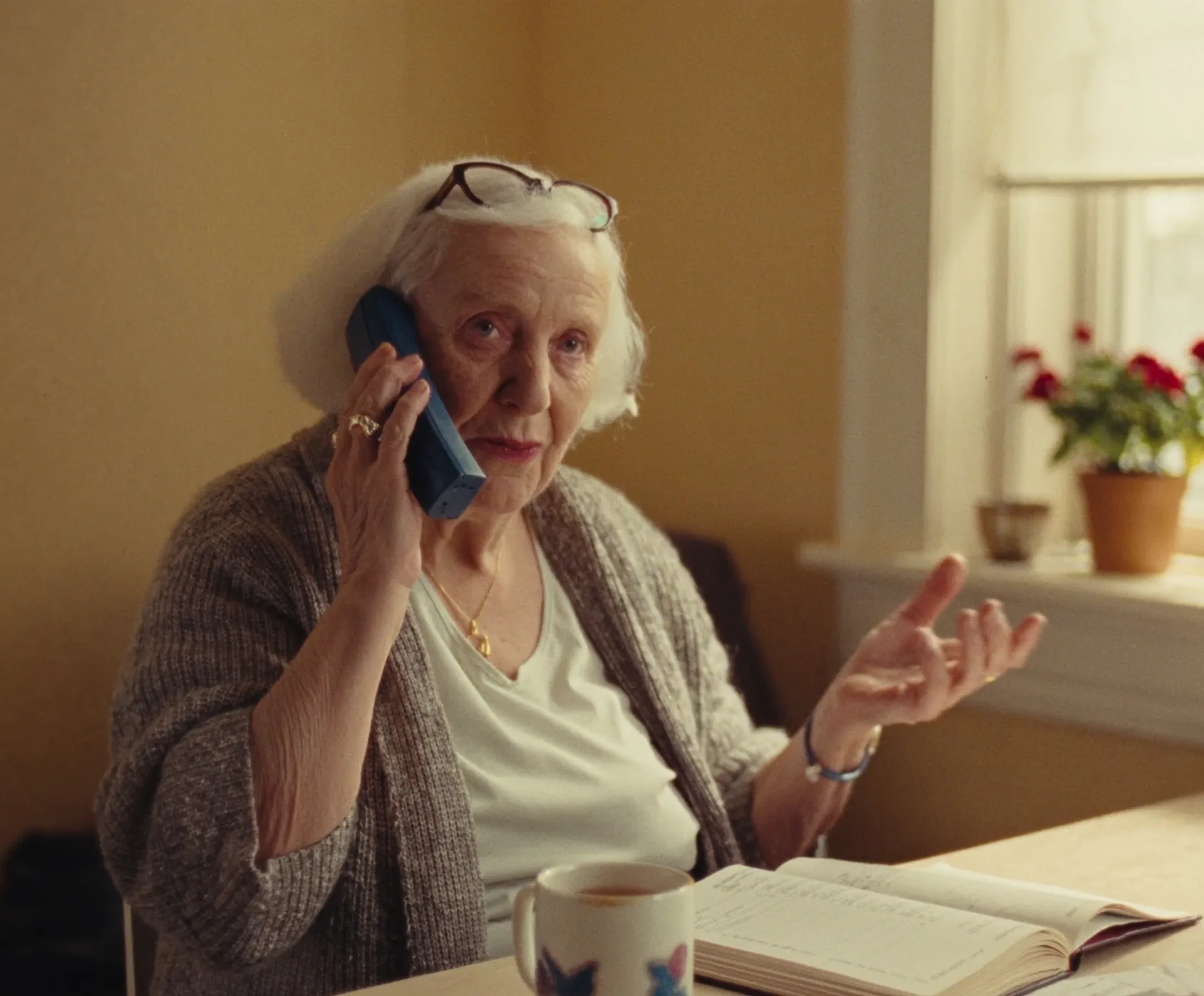 Margaret on the phone in her kitchen, mid-conversation